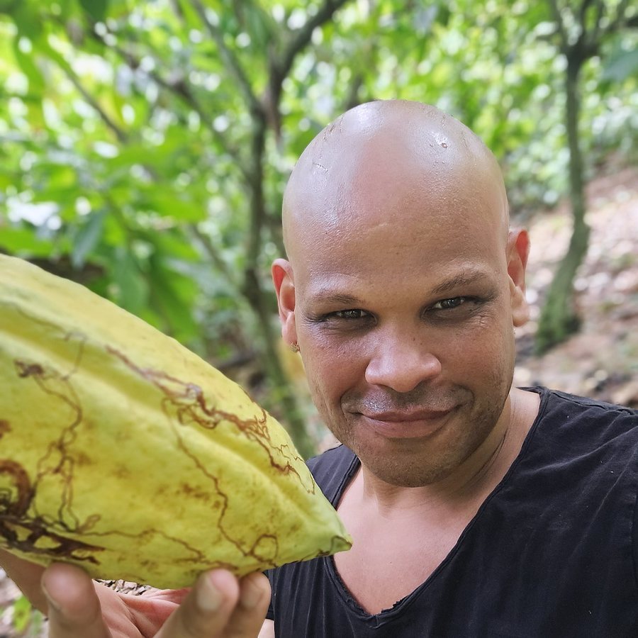 Kenny Santana mit einer Kakaofrucht auf der Plantage